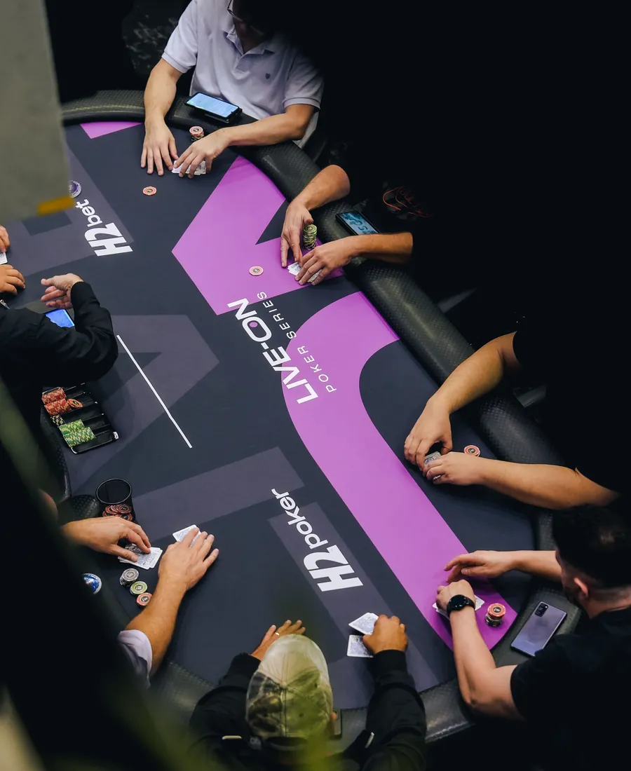 Mesa de poker oficial do H2 vista de cima, com vários jogadores