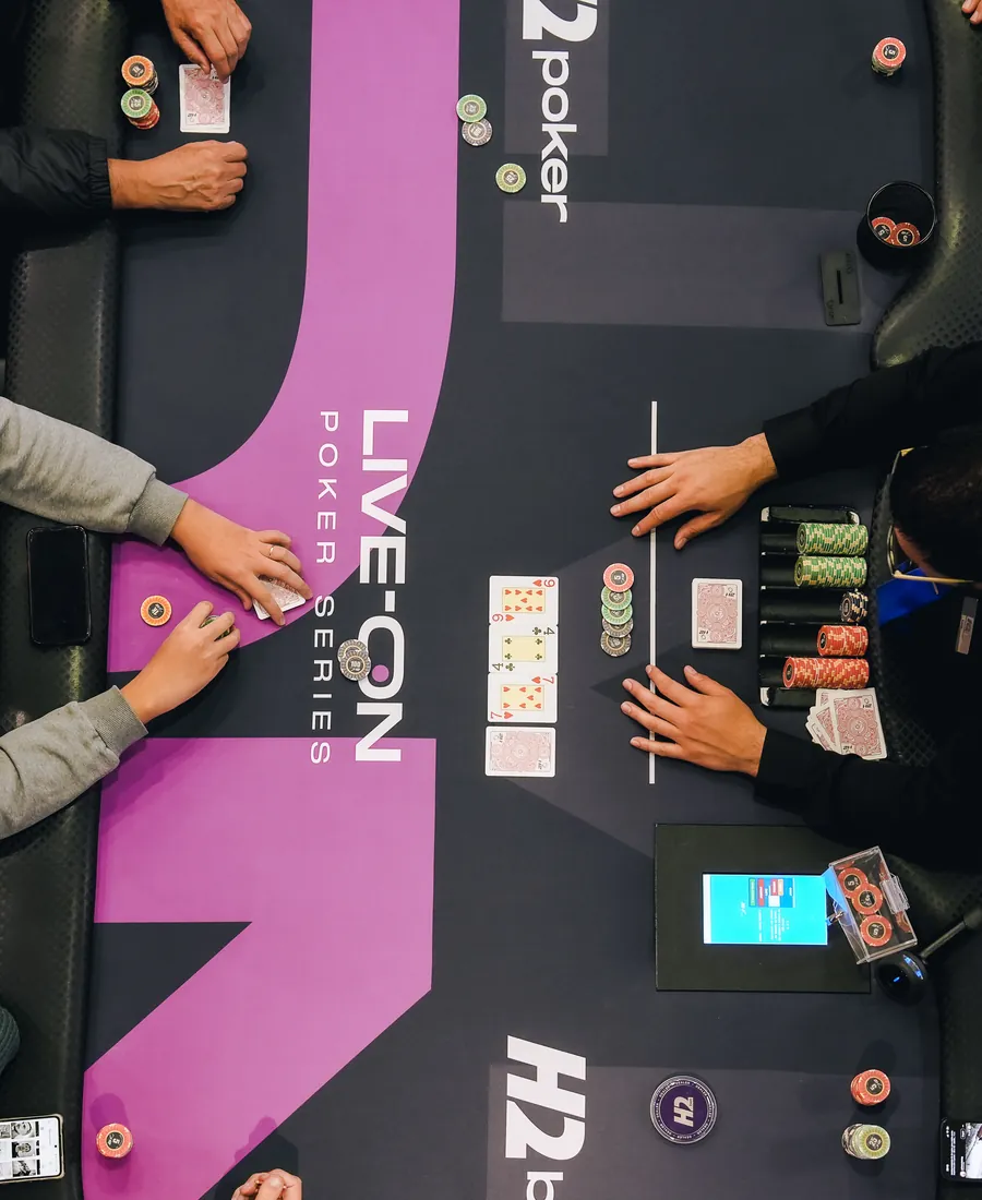 Mesa de poker do H2 SP com dealer e fichas
