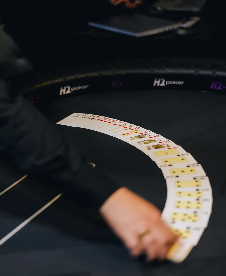 Dealer espalhando cartas sobre a mesa de poker