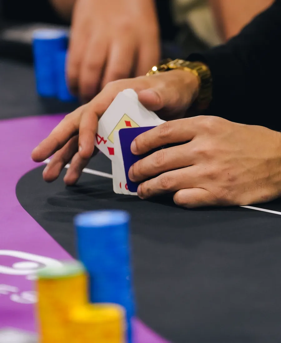 Mãos embaralhando cartas de poker sobre a mesa