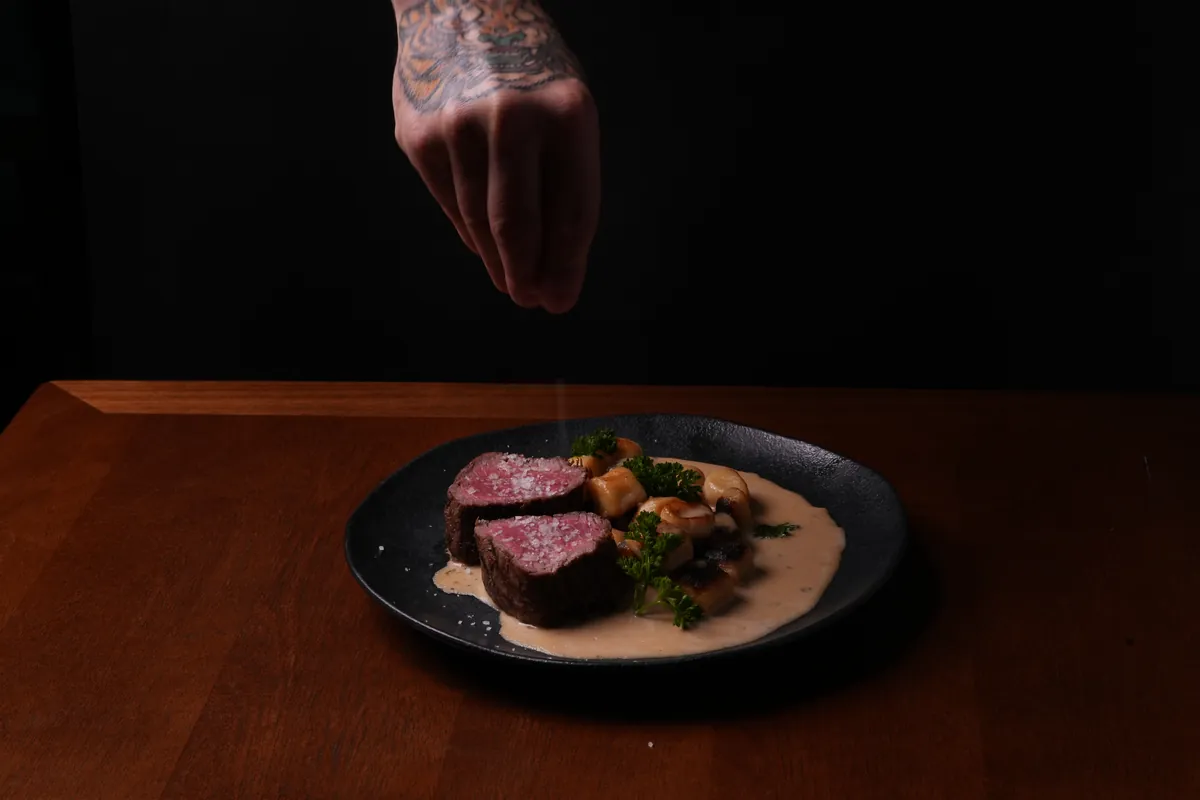 Chef finalizando o mignon com sal grosso