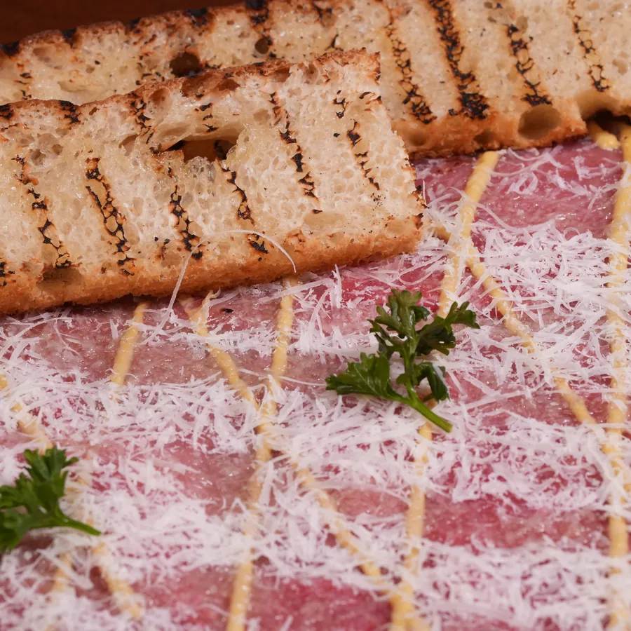 Carpaccio de carne bovina com parmesão ralado e torradas
