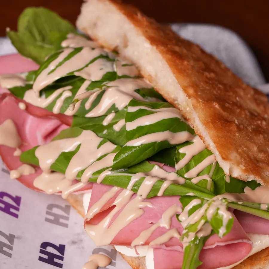 Sanduíche de mortadela italiana com rúcula em pão focaccia